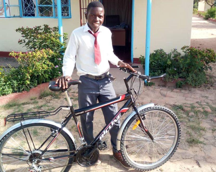 A volunteer donates a bike to a child in Africa