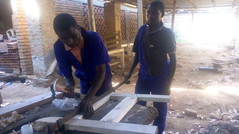 Gedion working as a carpenter